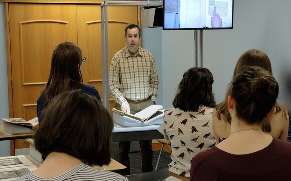 The monitor is shown mounted on the cart during a class with Dr. Robin Thomas, Associate Professor of Art History.
